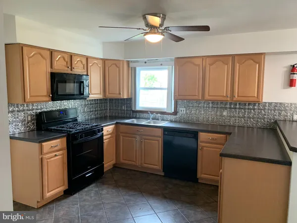 a kitchen with granite countertop a stove sink and microwave