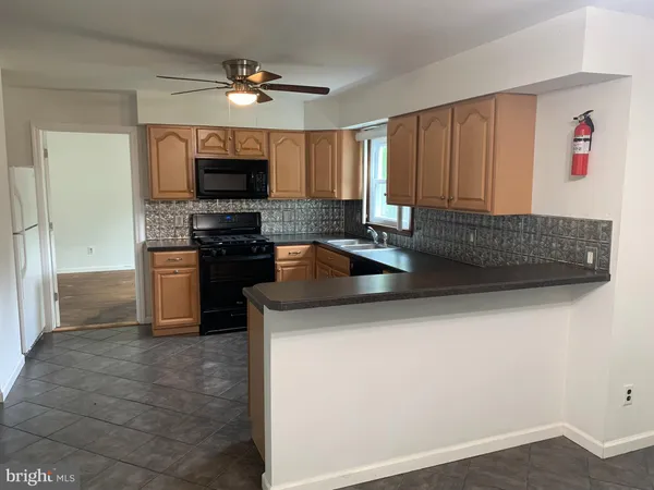 a kitchen with stainless steel appliances granite countertop a sink a stove and a refrigerator