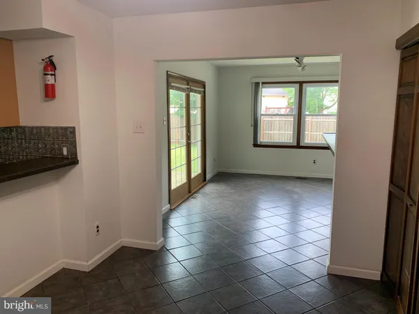 a view of an empty room with window and bathroom