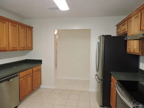 a kitchen with stainless steel appliances granite countertop a refrigerator a stove and a sink