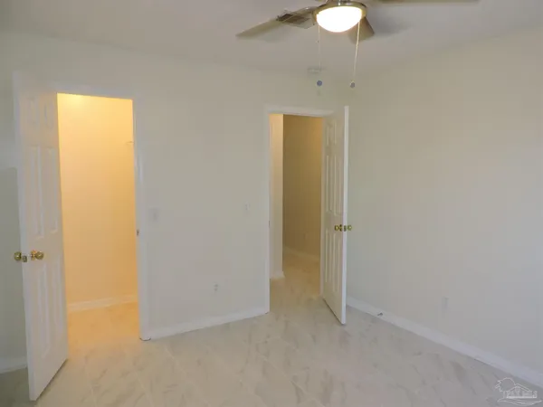 an empty room with a window and a fan