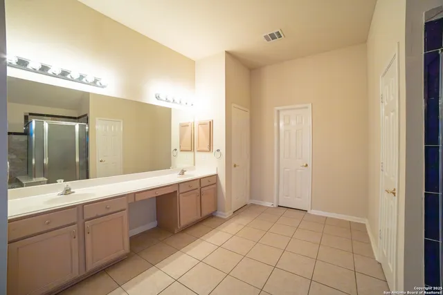 a spacious bathroom with a mirror sink and a shower