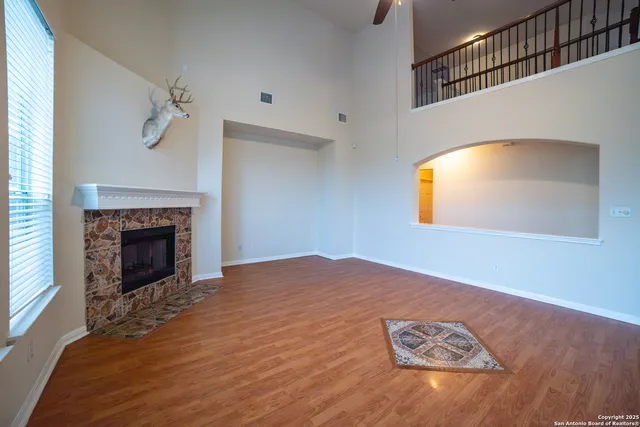 a view of an empty room with a fireplace and a window
