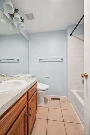 a spacious bathroom with a granite countertop sink a toilet a mirror and shower