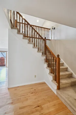 a view of staircase with lots of frames on wall and wooden floor