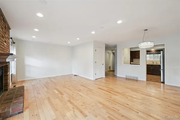 a view of empty room with wooden floor and fireplace