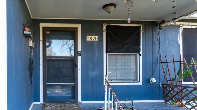 a view of a hallway with wooden floor and windows