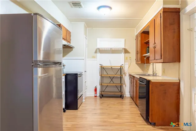 a view of kitchen with stainless steel appliances granite countertop cabinets and a window