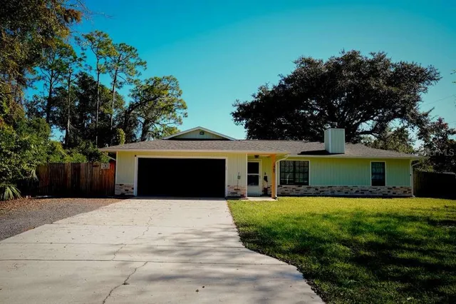 a front view of house with yard and trees