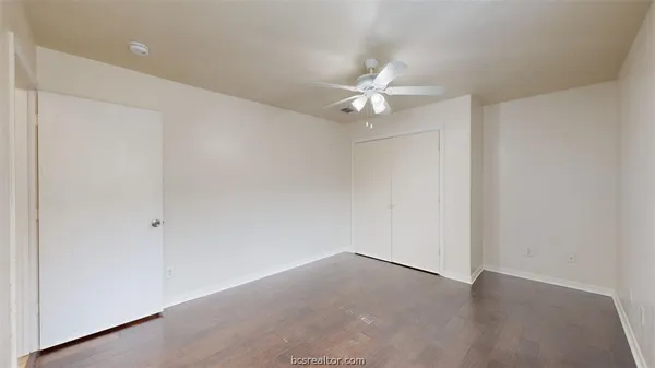 an empty room with a ceiling fan and a fan