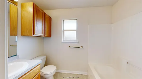 a white toilet sitting next to a bathroom sink and tub