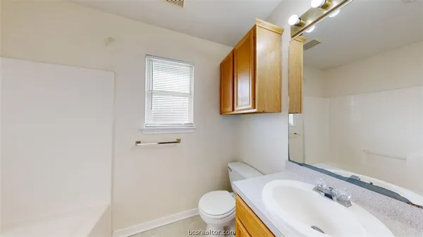 a bathroom with a sink mirror vanity and toilet