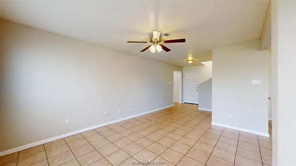 a view of a room with a chandelier fan and wooden floor