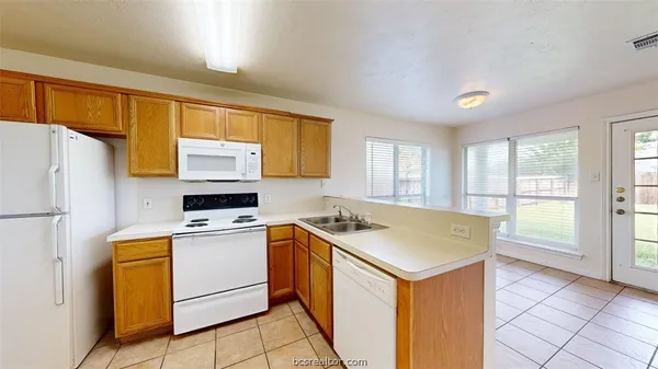 a kitchen with a sink a stove a refrigerator and cabinets