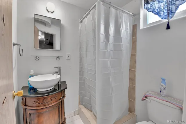 a bathroom with a toilet a sink and a mirror