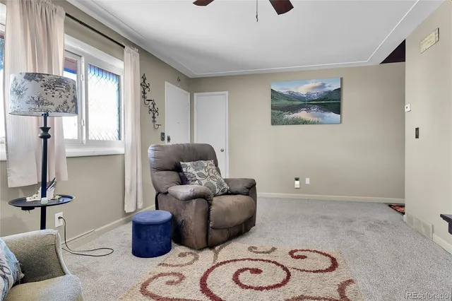 a living room with furniture a couch and two windows