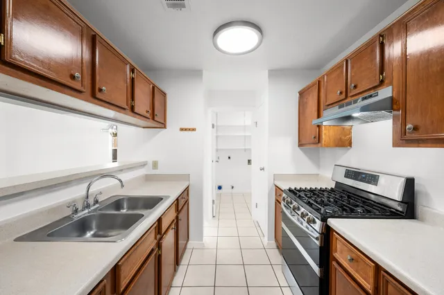 a kitchen with a sink stove top oven and cabinets