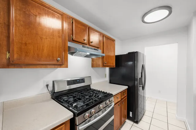 a kitchen with stainless steel appliances granite countertop a stove a refrigerator and a microwave