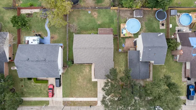 an aerial view of a house with swimming pool and large trees
