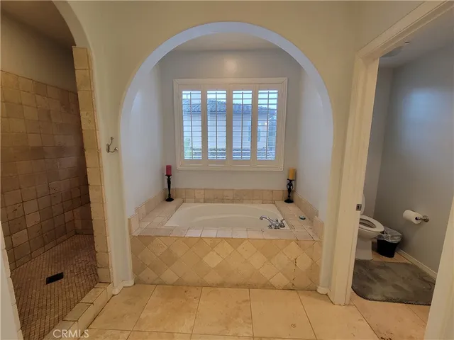 a bathroom with a tub shower and window