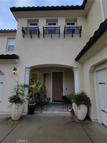 a view of a house with patio furniture and potted plants