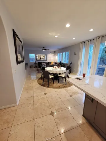 a living room with furniture a rug and a refrigerator