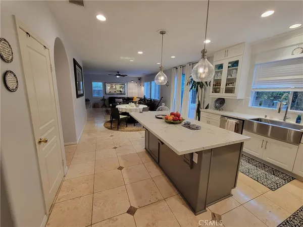 a kitchen with stainless steel appliances a stove a sink a refrigerator cabinets and dining table