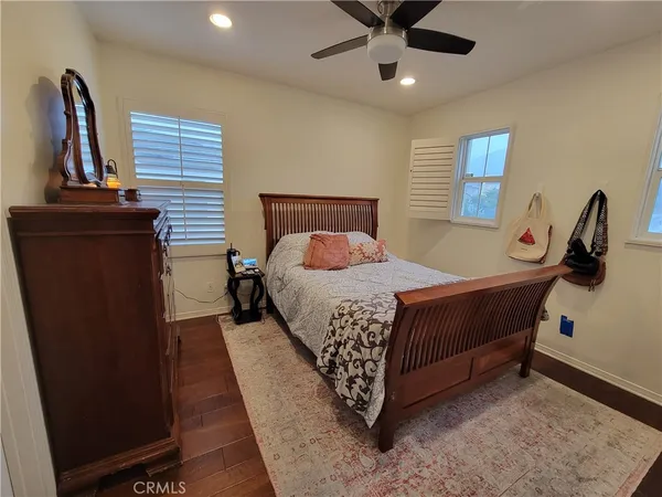 a bedroom with a bed and dresser with mirror