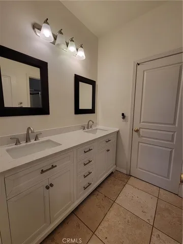 a bathroom with a double vanity sink and a mirror