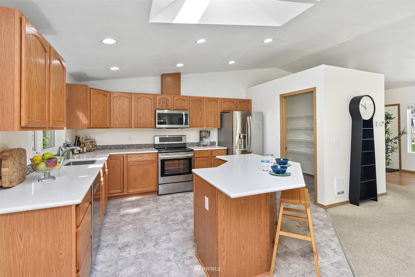 8963 Miller Road Northeast Bainbridge Island, WA 98110 - Photo 17 of 35 a kitchen with stainless steel appliances granite countertop a sink stove and refrigerator