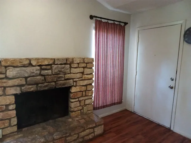 an empty room with wooden floor windows and cabinet