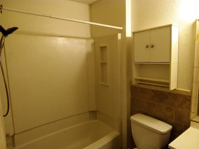 a bathroom with a shower a toilet and a sink