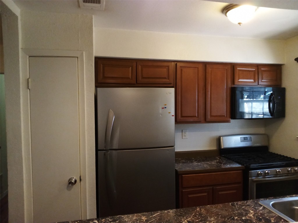 907 B Sirocco Drive Austin, TX 78745 - Photo 9 of 20 a kitchen with a refrigerator and a stove top oven