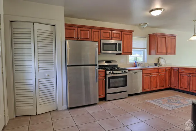 a room with kitchen island granite countertop a sink a counter top space and cabinets