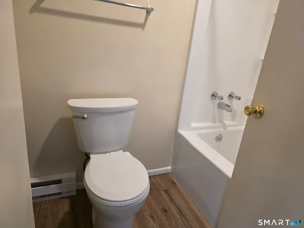 a white toilet sitting next to a white sink and vanity