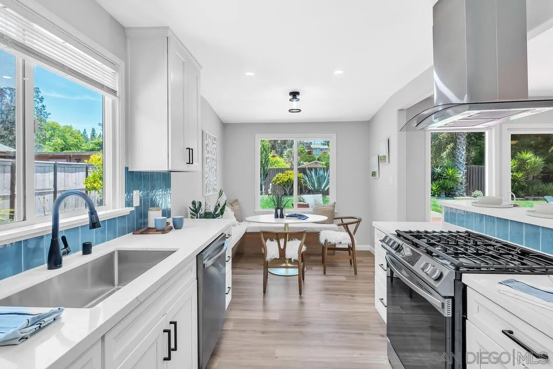 12208 Witt Road Poway, CA 92064 - Photo 14 of 43 a kitchen with stainless steel appliances granite countertop a stove top oven a sink dishwasher a dining table and chairs with wooden floor
