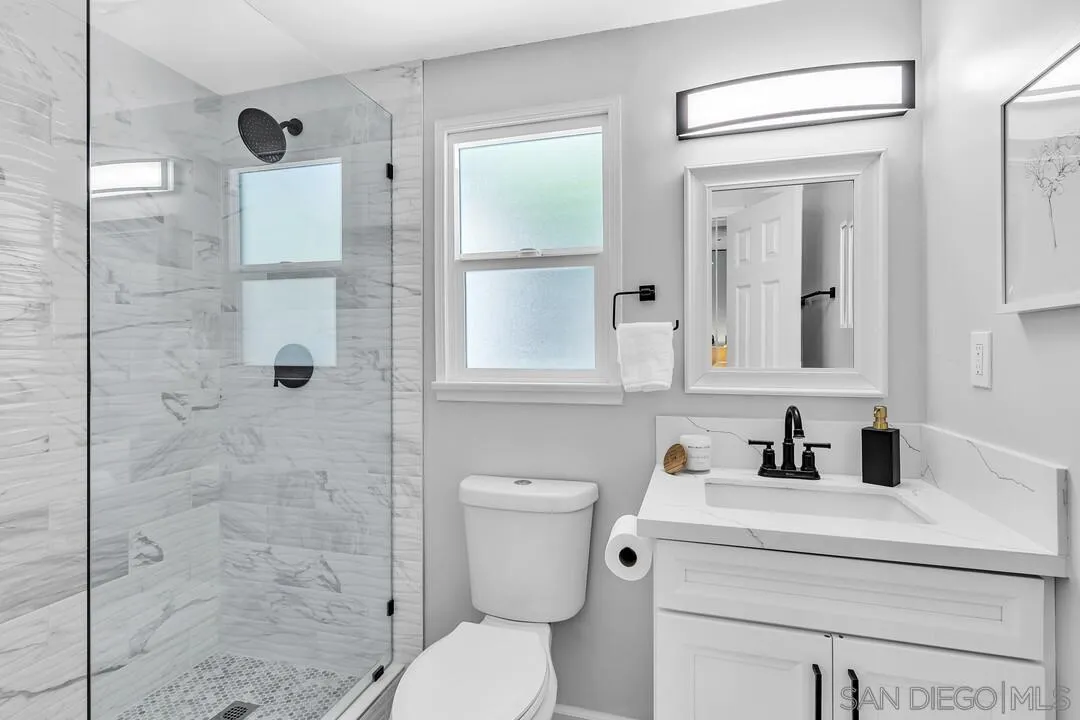 12208 Witt Road Poway, CA 92064 - Photo 19 of 43 a bathroom with a toilet sink vanity and shower