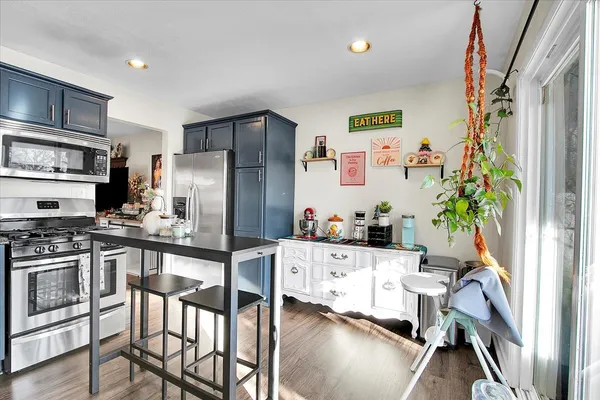 a kitchen with stainless steel appliances a stove a refrigerator and a dining table