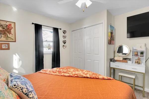 a bedroom with a bed and a flat screen tv