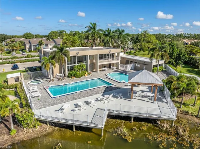 an aerial view of a house with swimming pool and a yard