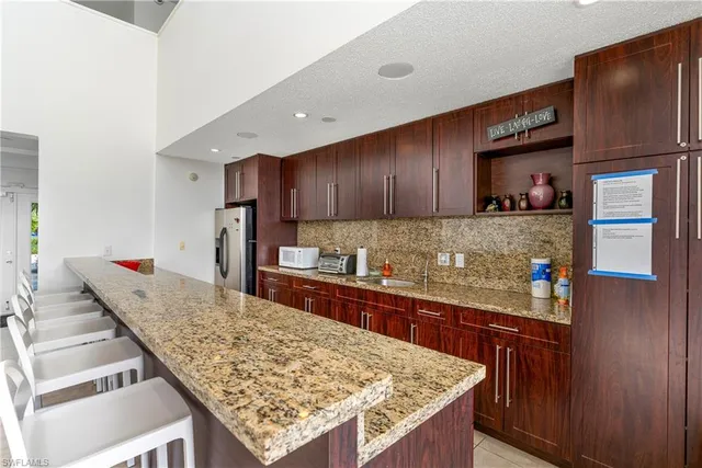 a kitchen with stainless steel appliances granite countertop sink stove refrigerator and cabinets