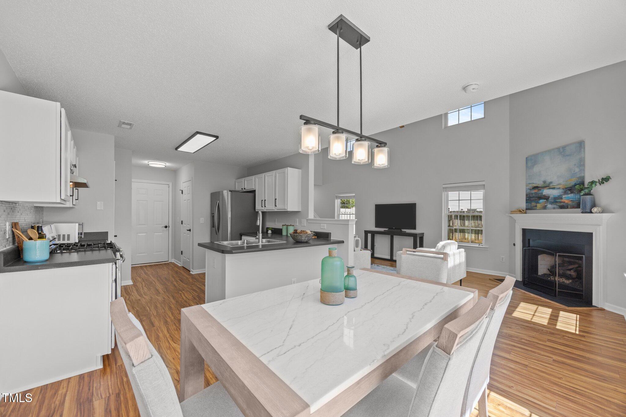 5300 Roan Mountain Place Raleigh, NC 27613 - Photo 9 of 27 a large kitchen with sink a refrigerator and chairs