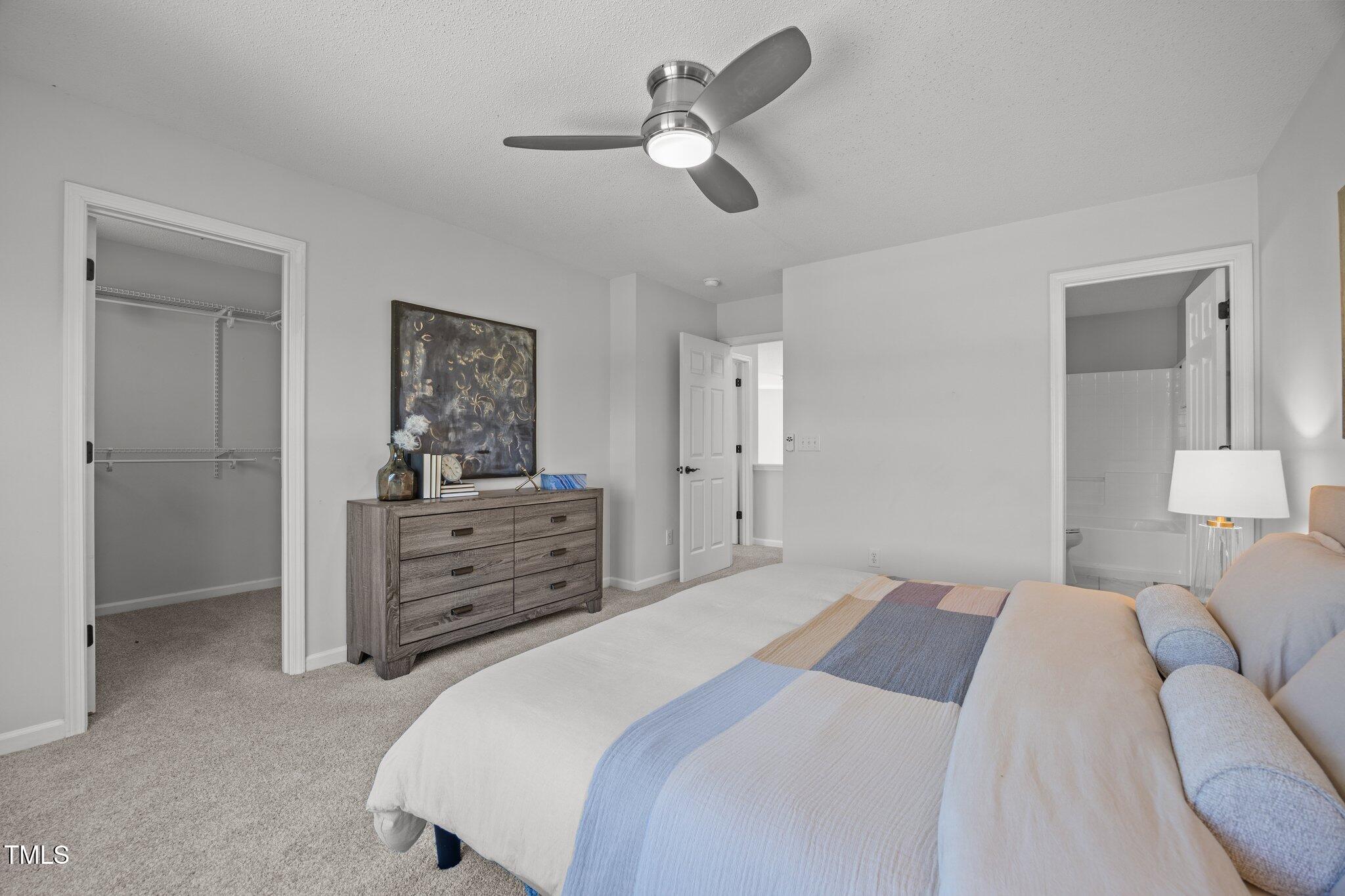 5300 Roan Mountain Place Raleigh, NC 27613 - Photo 16 of 27 a bedroom with a bed and a chandelier