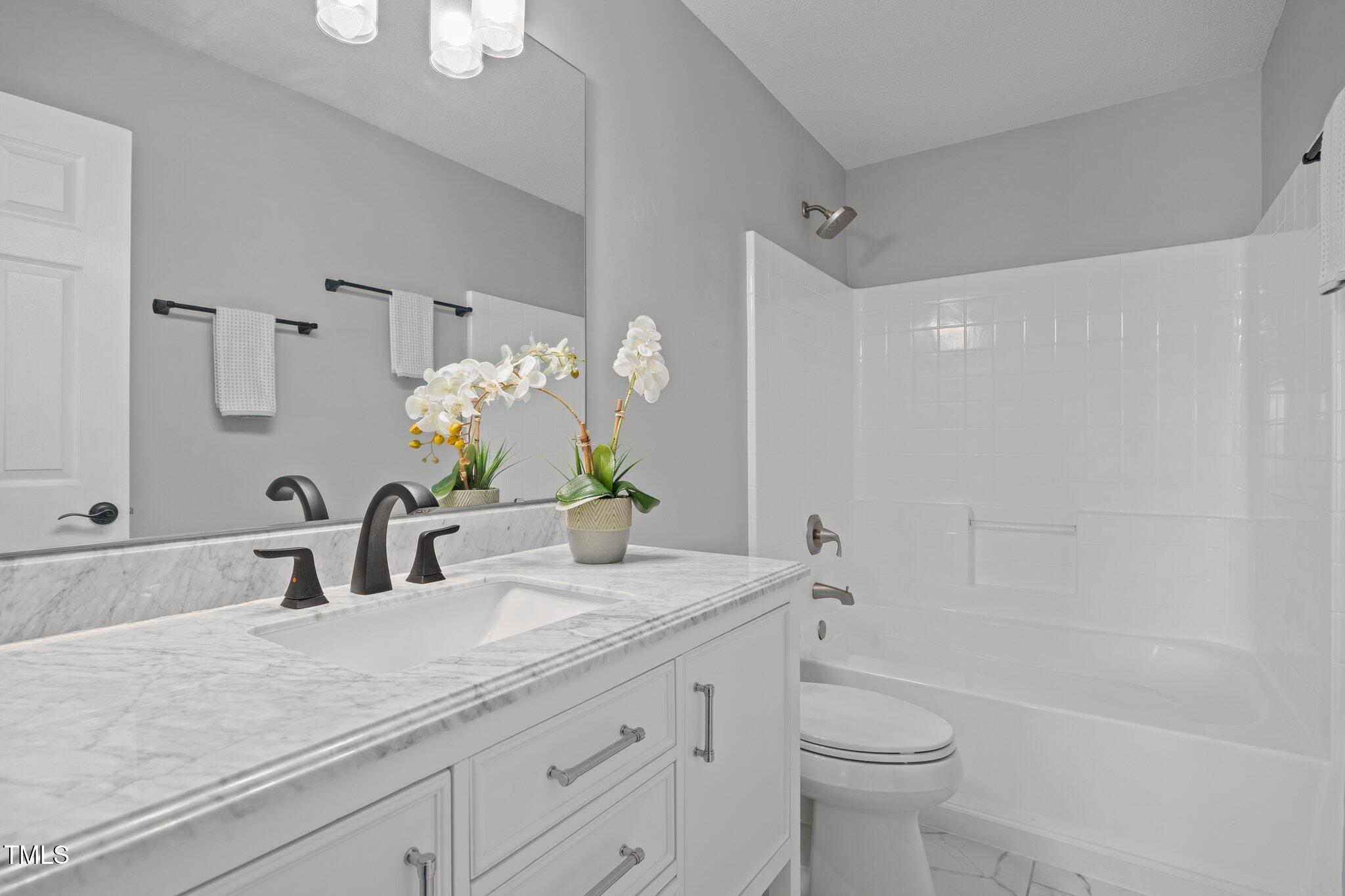 5300 Roan Mountain Place Raleigh, NC 27613 - Photo 18 of 27 a bathroom with a granite countertop sink a toilet and shower