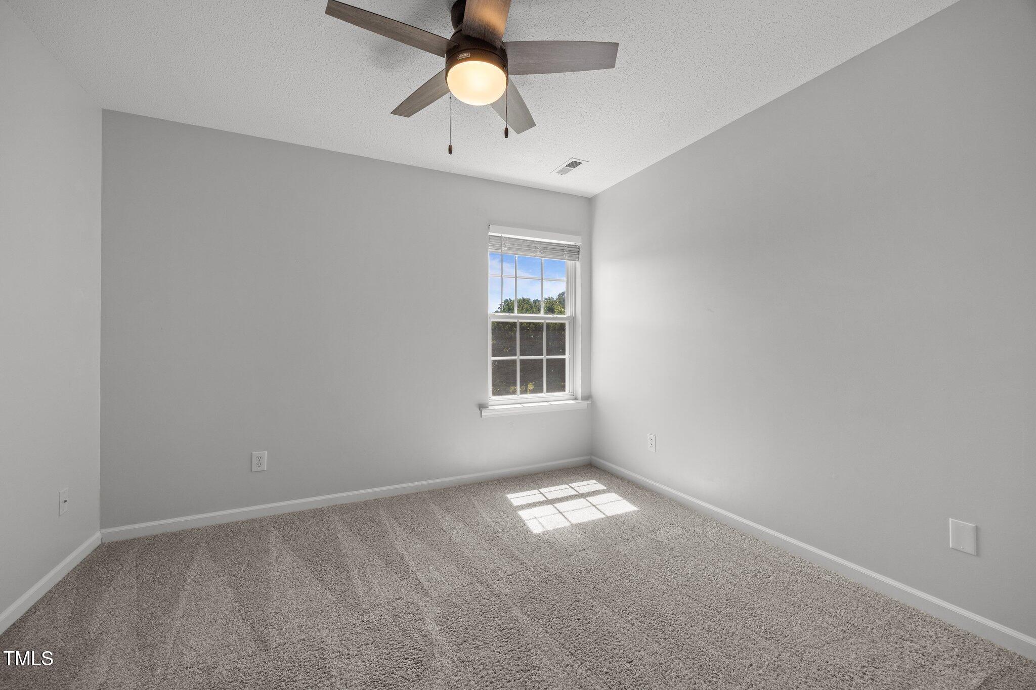 5300 Roan Mountain Place Raleigh, NC 27613 - Photo 19 of 27 an empty room with a window and a fan