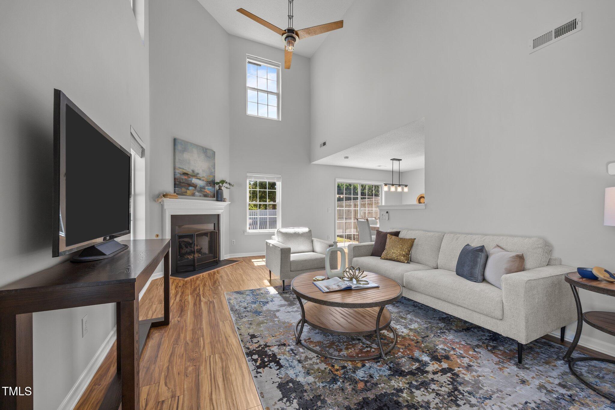 5300 Roan Mountain Place Raleigh, NC 27613 - Photo 2 of 27 a living room with furniture a fireplace and a flat screen tv