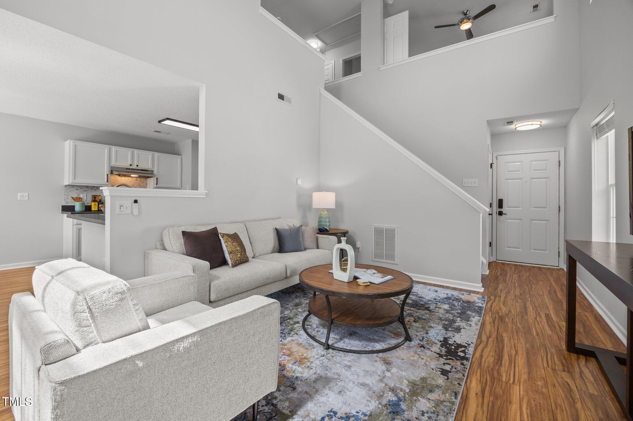 5300 Roan Mountain Place Raleigh, NC 27613 - Photo 3 of 27 a living room with furniture a rug and a wall painting