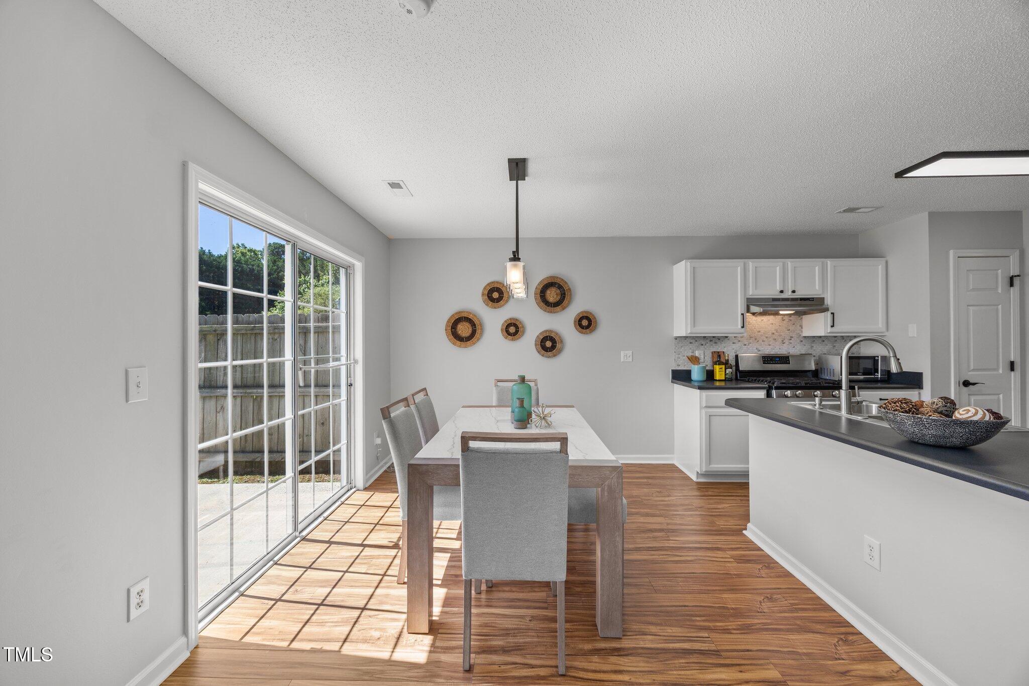 5300 Roan Mountain Place Raleigh, NC 27613 - Photo 7 of 27 a dining room with wooden floor and stainless steel appliances