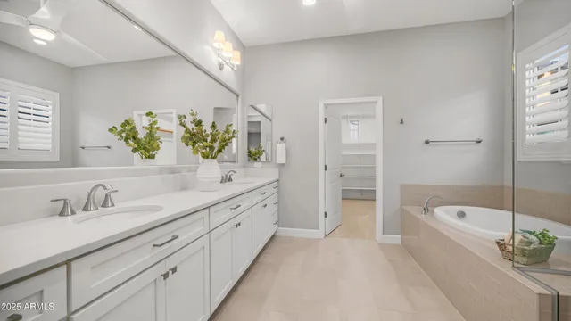 a spacious bathroom with a tub sink and mirror