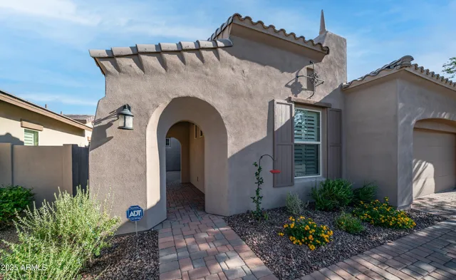 a view of a blue house with potted plants
